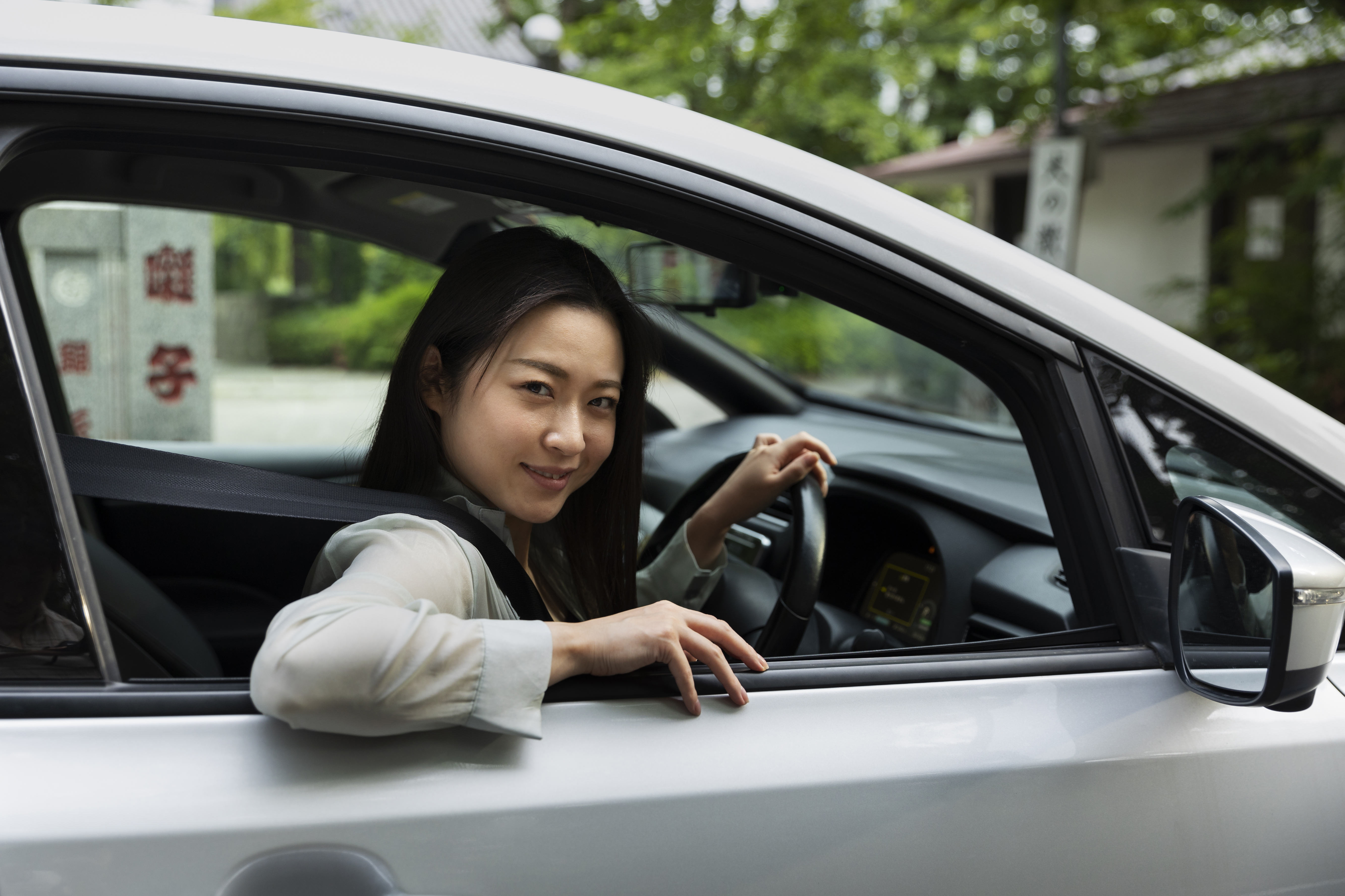 一位女性坐在车内,透过车窗微笑看向前方,神情轻松愉快。她即将离开繁忙的城市,踏上回家的旅程,脸上流露出对团圆与新年的期待,画面传达出自由、安心与回家过年的喜悦感受。